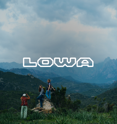 Personen in den Bergen und Lowa Logo