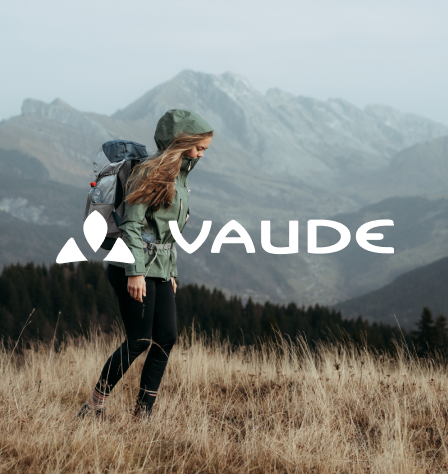 Person in den Bergen und Vaude Logo