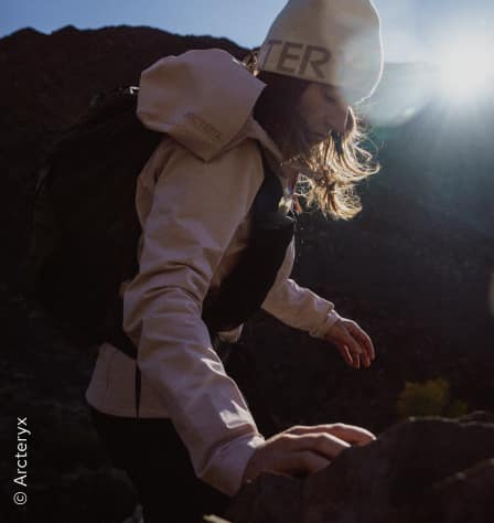 Frau in Jacke in den Bergen